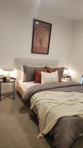 Seffadom apartments Melbourne cbd في ملبورن: غرفة نوم بسرير كبير عليها مخدات