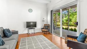 Elizabeth Beach Guest House في Elizabeth Beach: غرفة معيشة مع أريكتين وتلفزيون بشاشة مسطحة