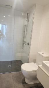 Seffadom apartments Melbourne cbd في ملبورن: حمام ابيض مع مرحاض ودش