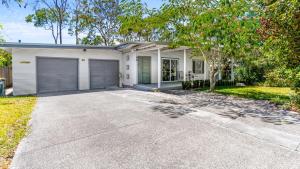 Elizabeth Beach Guest House في Elizabeth Beach: منزل به جراج مع ممر