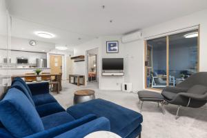 a living room with a blue couch and a tv at 1BR Stylish Condo central Village Location with Private Balcony in Whistler