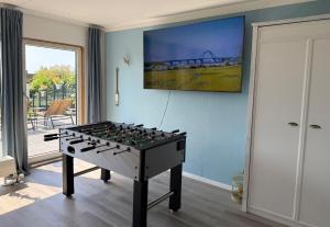 a foosball table in a room with a painting at Ferienwohnung-Maren in Marienleuchte
