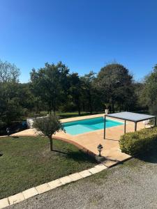 a swimming pool with a table and a tennis racket at Domaine de pierre blanche in Pern +15 photos