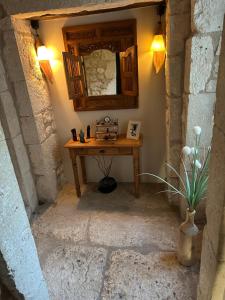 a room with a table with a mirror and a vase at Domaine de pierre blanche in Pern