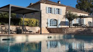a house with a swimming pool in front of a house at Domaine de pierre blanche in Pern