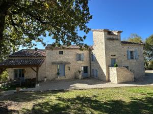 an external view of a stone house with a tree at Domaine de pierre blanche in Pern