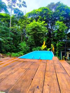 Una gran terraza de madera con una piscina azul. en Monstera Forest Lodge, en Fortuna 27 fotos más