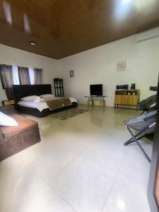 Una gran sala de estar con una cama y un televisor. en Monstera Forest Lodge, en Fortuna