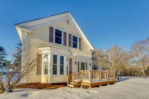 een klein wit huis met een veranda in de sneeuw bij Charming Wilton Vacation Rental with Fire Pit in Wilton