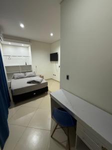 a bedroom with a bed and a desk in it at Posada Familiar Encarnación de Siberia Group in Encarnación