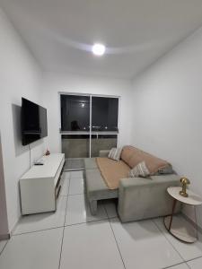 Una sala de estar con un sofá y un televisor. en AP a 3KM das PRAIAS, com SUÍTE, en São Luís