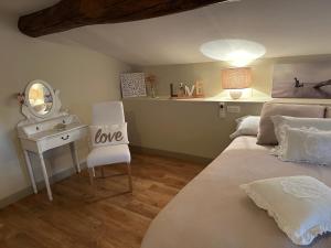 a bedroom with a bed and a desk with a mirror at Domaine de pierre blanche in Pern