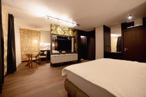 ノヴィサドにあるKronのベッドとテーブルのあるホテルの部屋