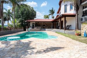 a swimming pool in front of a house at Casa de Campo c 4 Suites AC Wi-Fi em Sao Roque in Mairinque