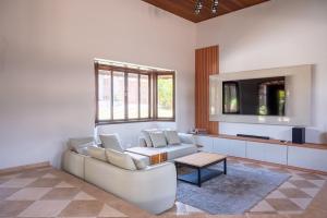 a living room with a white couch and a table at Casa de Campo c 4 Suites AC Wi-Fi em Sao Roque in Mairinque