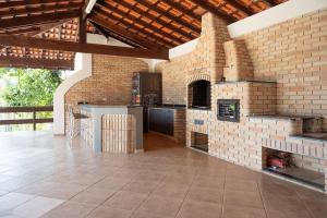 an outdoor kitchen with a brick wall at Casa de Campo c 4 Suites AC Wi-Fi em Sao Roque in Mairinque