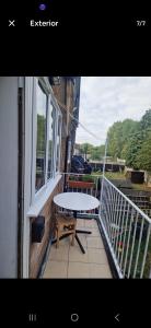 a white table and chair on a balcony with a window at Andrea house in Thornton Heath