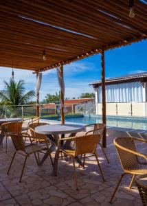 Meu Xodó Pousada في ببرانا: فناء مع طاولة وكراسي وحمام سباحة