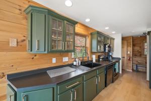 a kitchen with green cabinets and a counter top at Sugar View Chalet in Banner Elk