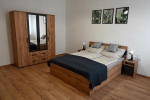 ニーレジハーザにあるPalatini Apartmanのベッドルーム1室(大型木製ベッド1台、窓付)