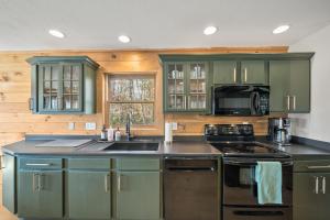 a kitchen with green cabinets and a stove top oven at Sugar View Chalet in Banner Elk +27 photos