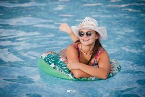 uma mulher de chapéu e óculos de sol numa piscina em Cabañas La Soñada em Chajarí