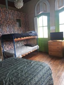 Hostal del Gato valparaiso في فالبارايسو: غرفة نوم بسريرين وخزانة ونافذة