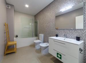ein Badezimmer mit Toilette, Waschbecken und Spiegel in der Unterkunft Modern & Quiet 2BR 2 Baths 4 Balconies & Lift in Ílhavo