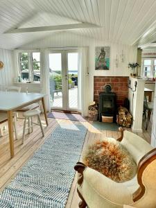 a living room with a fireplace and a table at 180 Degree View Over Sebbersund Fjord in Nibe