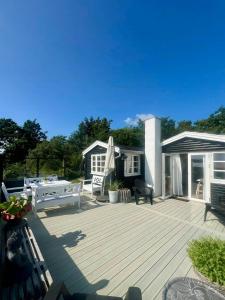 a wooden deck with a table and chairs on it at 180 Degree View Over Sebbersund Fjord in Nibe