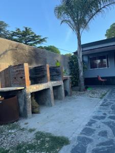 a wooden bench sitting next to a wall at Casa Familia Mateo in Santa Teresita