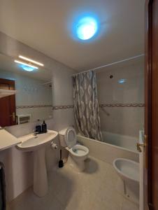 un bagno con un water, un lavandino e uno specchio di Los Tinajones a La Oliva