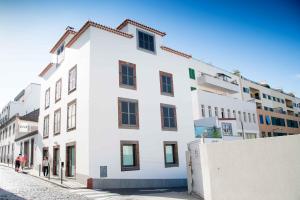 un edificio bianco sul lato di una strada di Casa dos Avós Apartments a Funchal