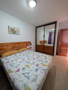 una camera da letto con un letto con un piumone colorato di Los Tinajones a La Oliva