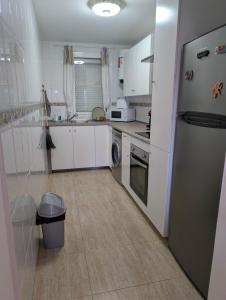 una cucina con mobili bianchi e un frigorifero di Los Tinajones a La Oliva