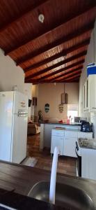 a kitchen with white appliances and a wooden ceiling at Casa de Bonito in Bonito