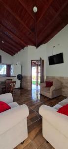 a living room with two white couches and a television at Casa de Bonito in Bonito