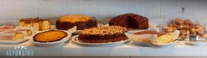 a bunch of different types of cakes on a shelf at Hotel La Alfonsina in Santibáñez de Villacarriedo