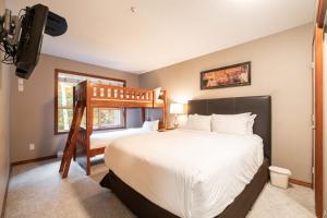 a bedroom with a bed and a bunk bed at Aspens Lodge 220 by Outpost Whistler in Whistler