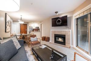 a living room with a couch and a fireplace at Aspens Lodge 220 by Outpost Whistler in Whistler