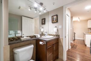 a bathroom with a toilet and a sink and a mirror at Aspens Lodge 220 by Outpost Whistler in Whistler +29 photos