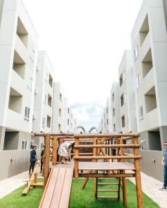 un banco de madera en el medio de un edificio en Apartamento completo com lazer, en João Pessoa