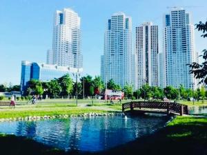 28th Floor Sky City View Apartment في إسكوبية: جسر فوق نهر في مدينة ذات مباني طويلة