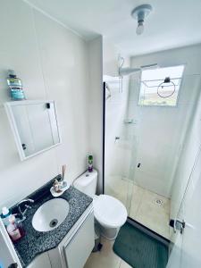 Un baño con inodoro, lavabo y ducha. en Cond Millenium residênce, en Juiz de Fora