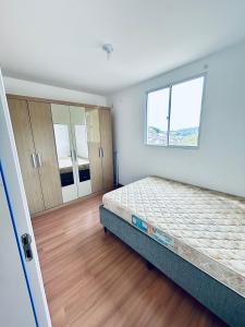 un dormitorio vacío con una cama y una ventana en Cond Millenium residênce, en Juiz de Fora