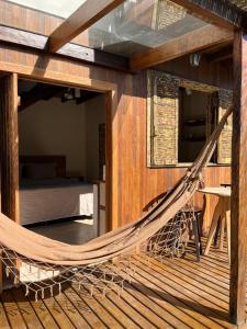 a hammock in the middle of a room with a bed at Cabana na Natureza Com Hidro - Baoba Suites in Bombinhas