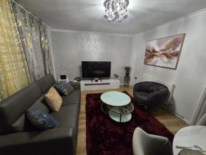 a living room with a couch and a tv at Hornchurch Cozy 2-Bed Flat with Street Parking in Hornchurch