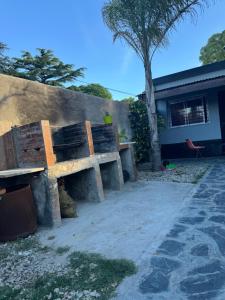 a wooden bench sitting next to a wall at Casa Familia Mateo in Santa Teresita