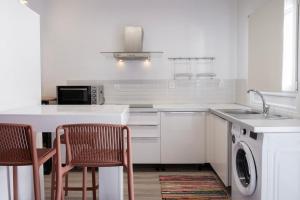 Una cocina blanca con fregadero y lavavajillas. en Casa Poco, 150 meters from Ornos Beach, en Ornos 4 fotos más