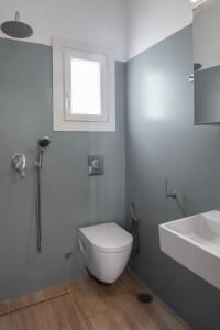 Un baño con inodoro, lavabo y ventana. en Casa Poco, 150 meters from Ornos Beach, en Ornos